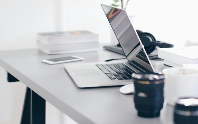 silver MacBook Pro on white table